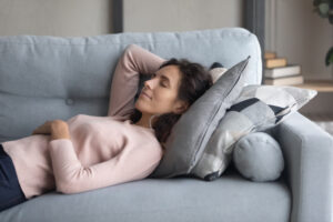 PeacefulYoungHappyWomanLyingOnSoftPillowOnComfortable