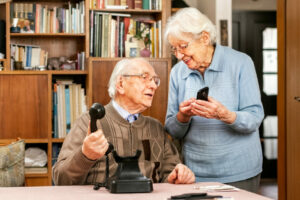 GrandfatherWithOldTelephoneAndGrandmotherWithSmartphone