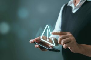 SystemHackedWarningAlertManUsingSmartphoneWithCyberAttack