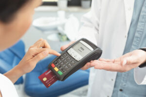 DoctorIsHoldingPaymentTerminalInHands.PayingForHealth