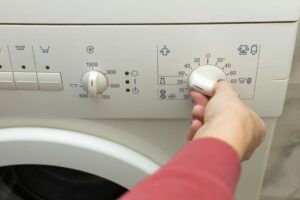 a-person-chooses-a-washing-mode-with-a-switch.-temperature-mode.-washing-machine