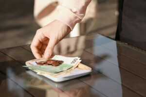 WaitressTakingPaymentForOrderFromWoodenTableAtOutdoor