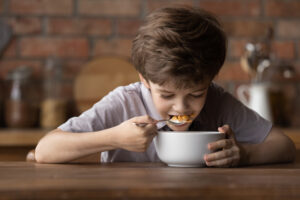 CloseUpHappyCuteLittleBoyEatingSweetTastyDelicious