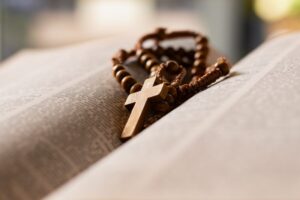 Wooden,Cross,Placed,On,Opened,Page,Book,,Soft,Focus,,Concept
